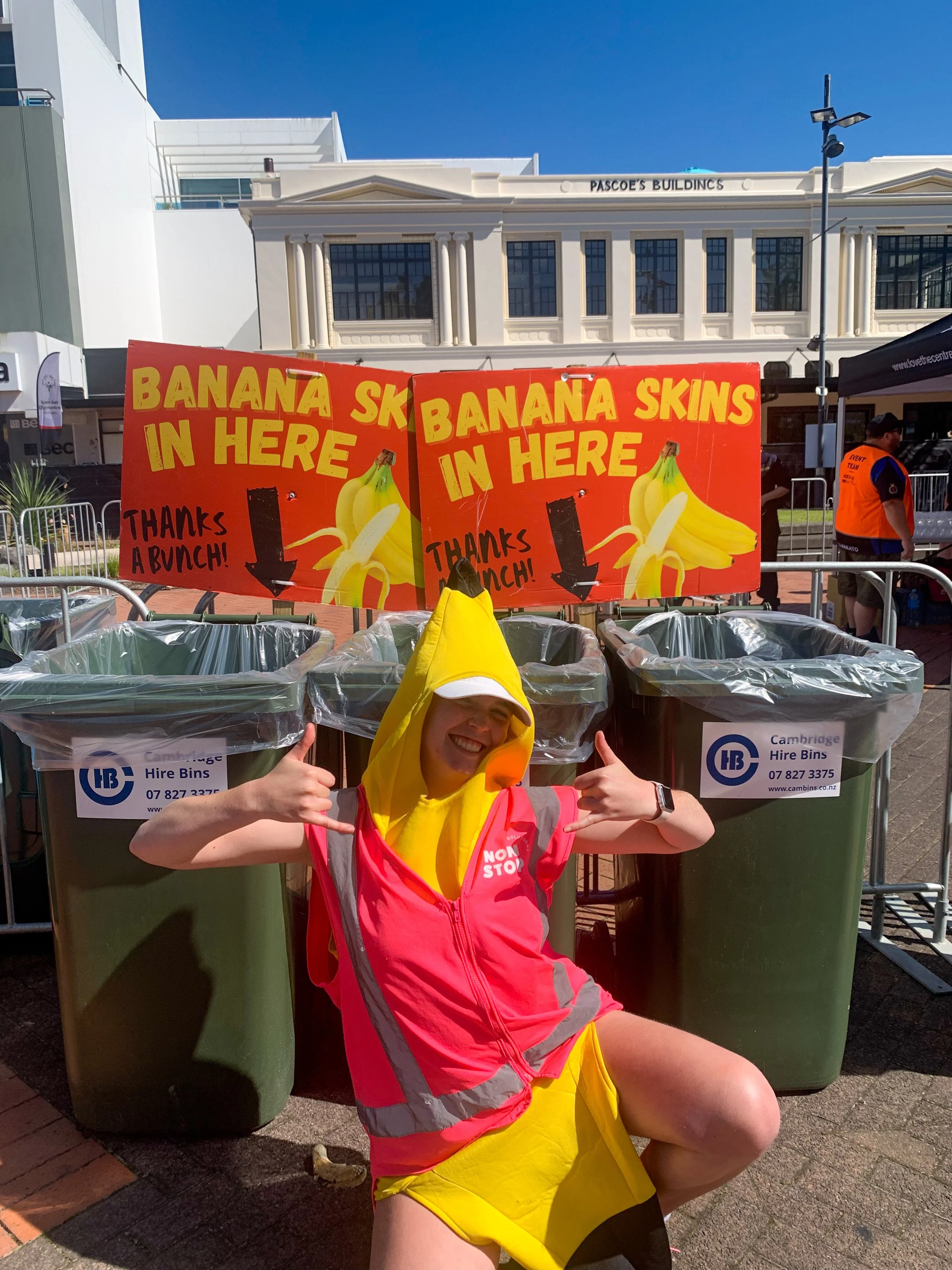 Nonstop solutions team member in banana suit in front of banana only bins at round the bridges event