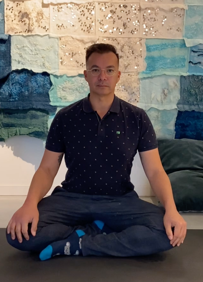 Marcel, yogadocent en oprichter van Urbanlife, mediterend in lotushouding