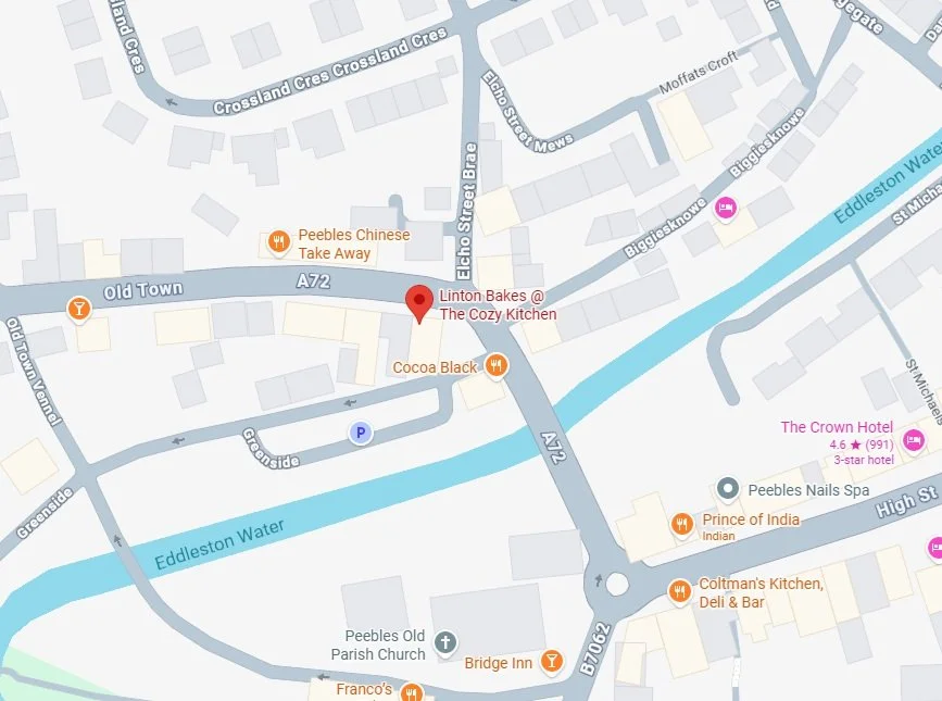 Map displaying streets, a river, and various local businesses including cafes, hotels, and restaurants in Peebles, Scotland.