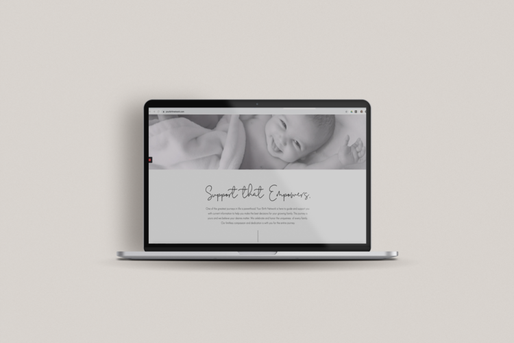 Laptop displaying a website with a black and white photo of a smiling baby at the top. Website designed by Brim and Bold Creative.