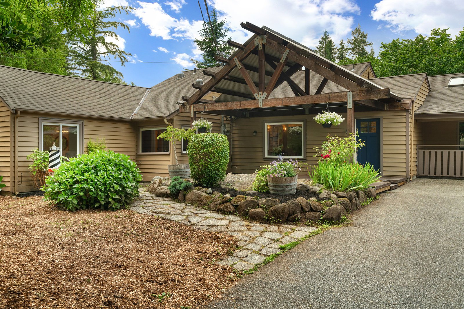 view of a brown house with flowers and a blue door