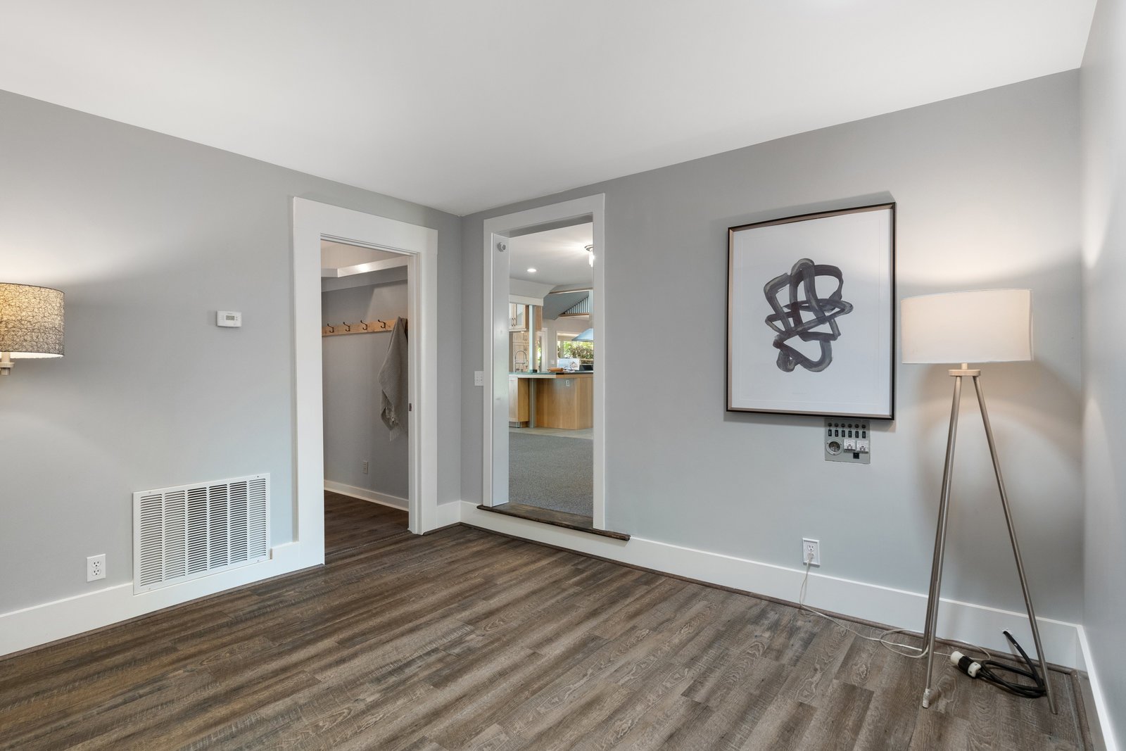 view of a gray room with a wood floor and a lamp