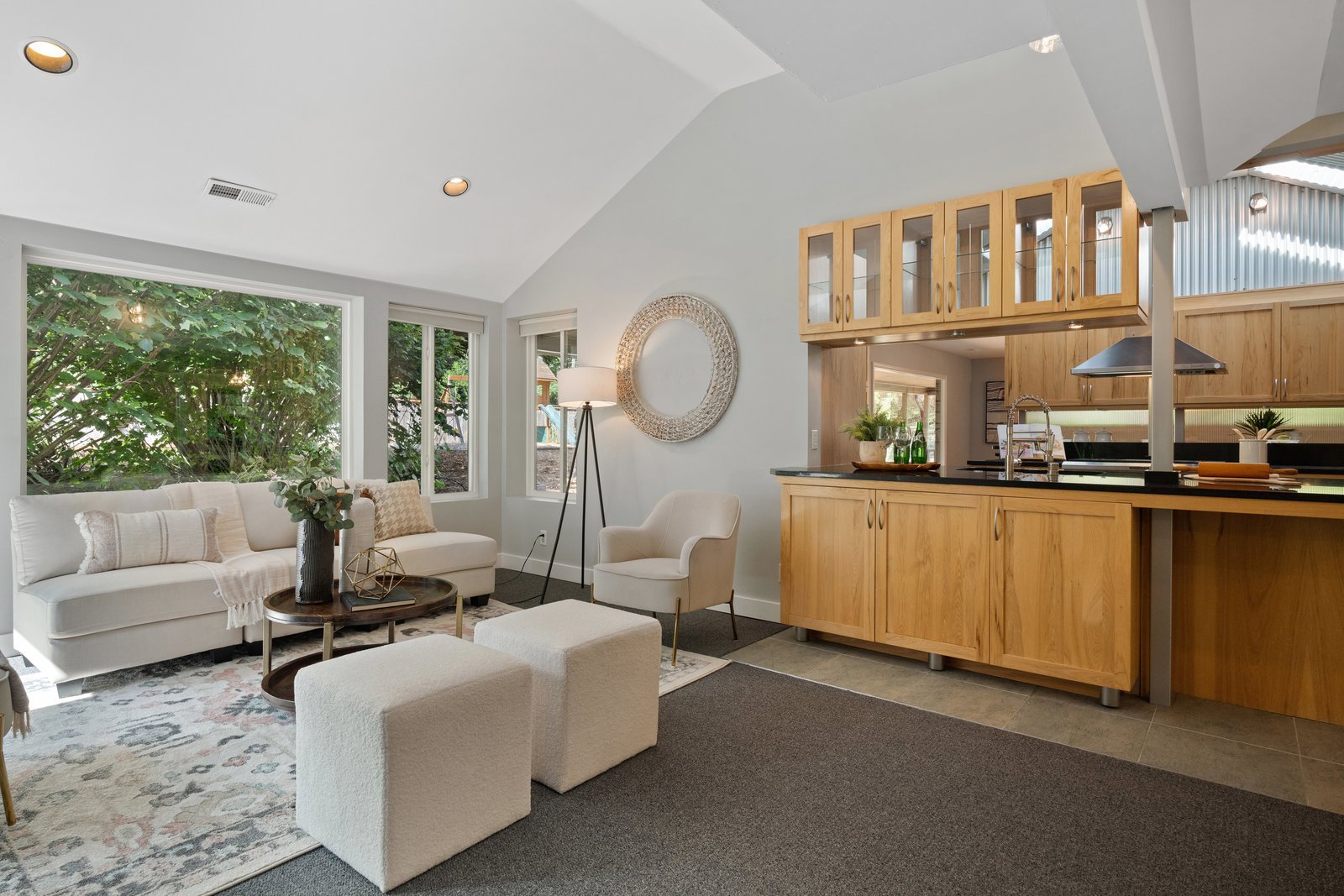 view of the open concept kitchen from the living room with a white couch and dual ottomans