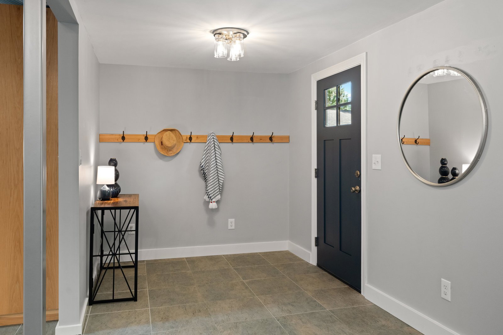 view of the entry way with a blue door and coat rack on the wall
