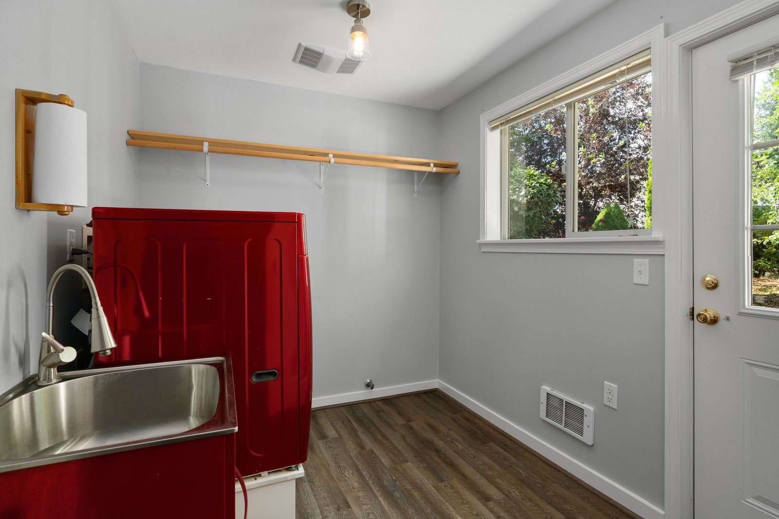 view of the laundry room with a red washer and sink and a white dryer