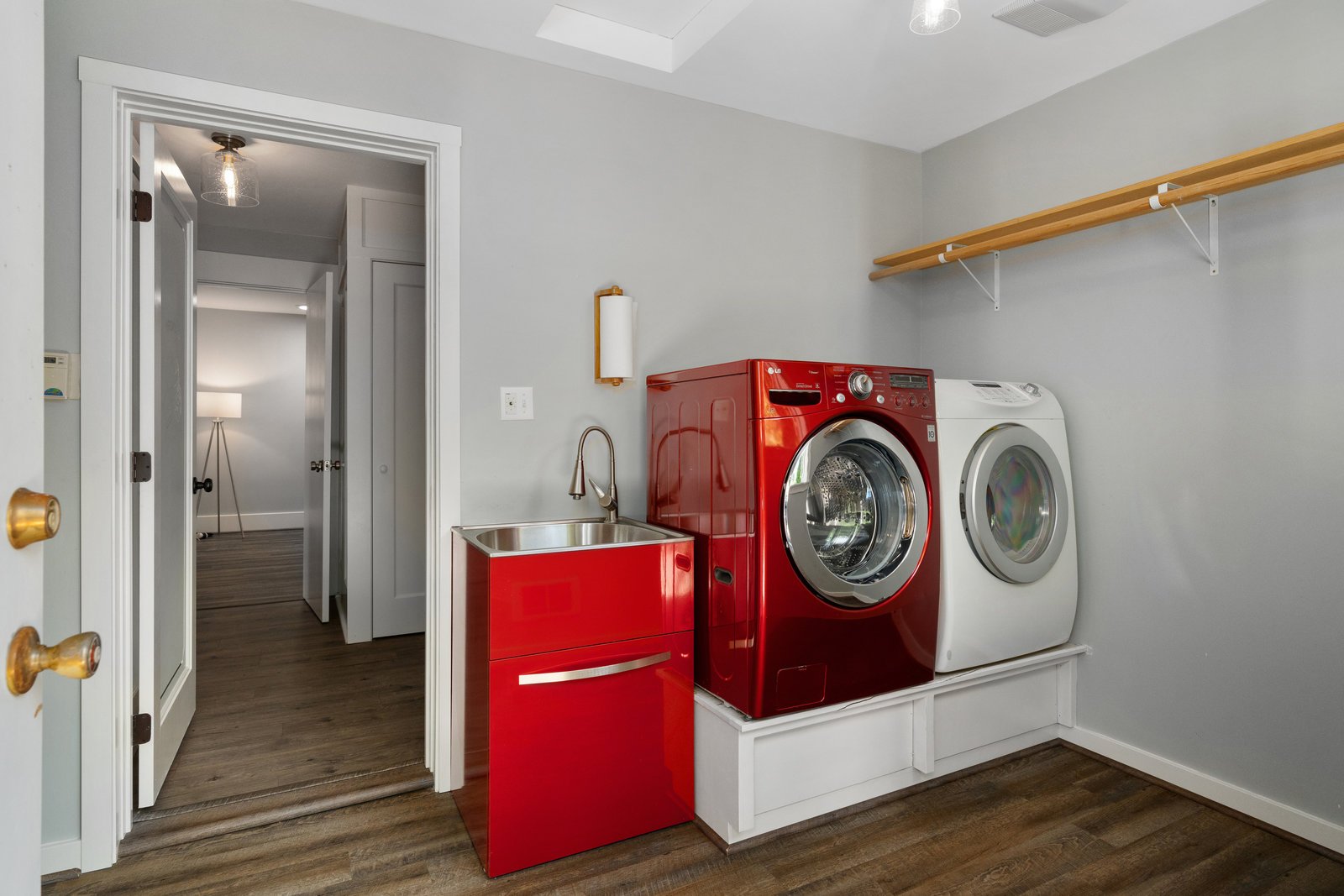 view of the laundry room with a red washer and sink and a white dryer