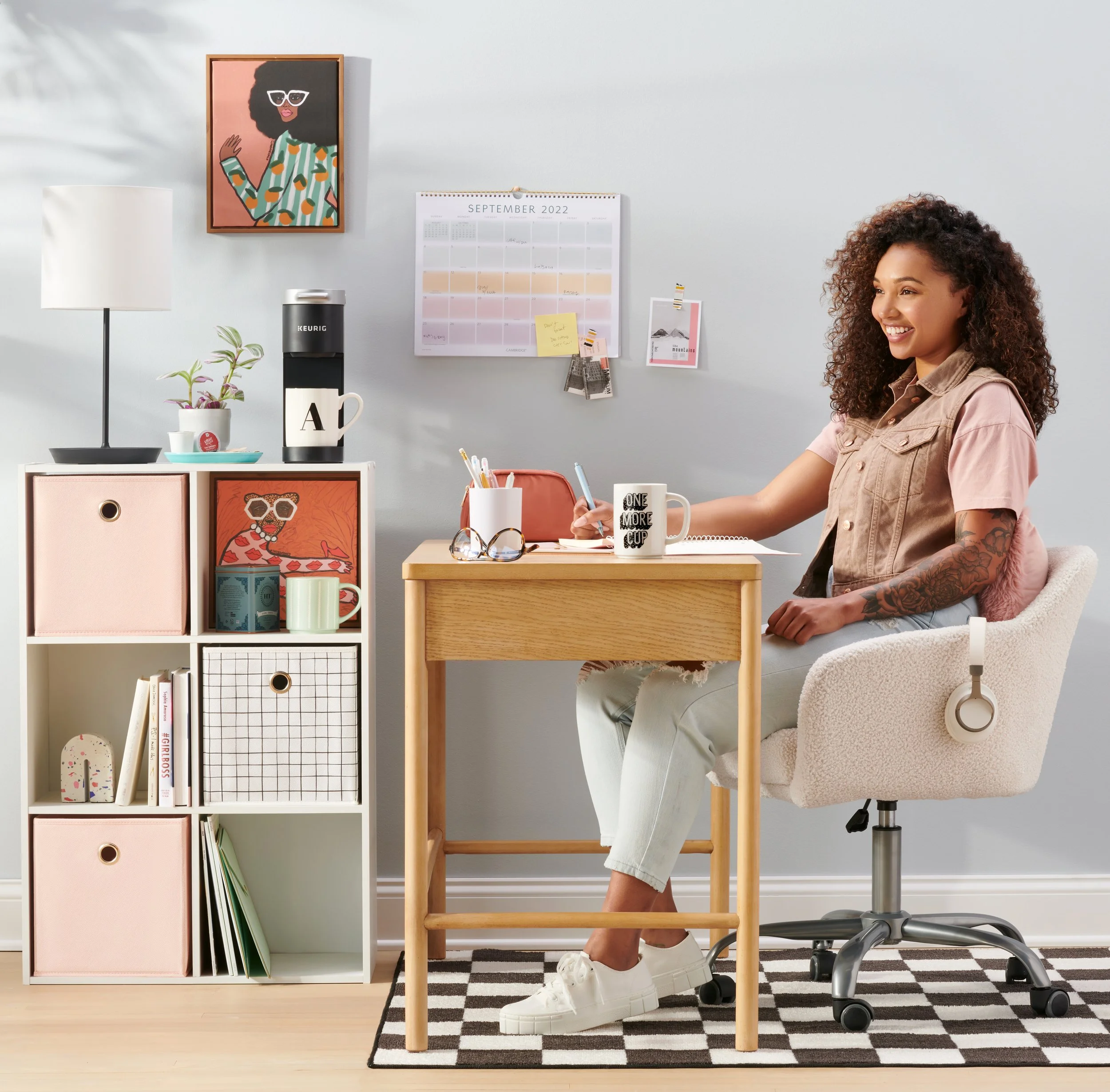 teen in college dorm room with bookshelf desk art and coffee