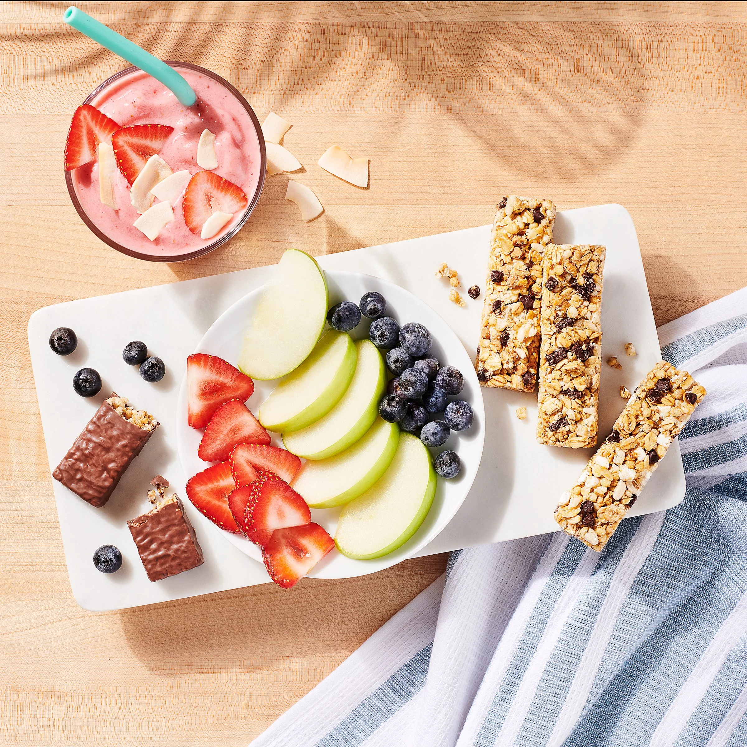 morning breakfast options with granola bars apples blueberries strawberries and smoothie