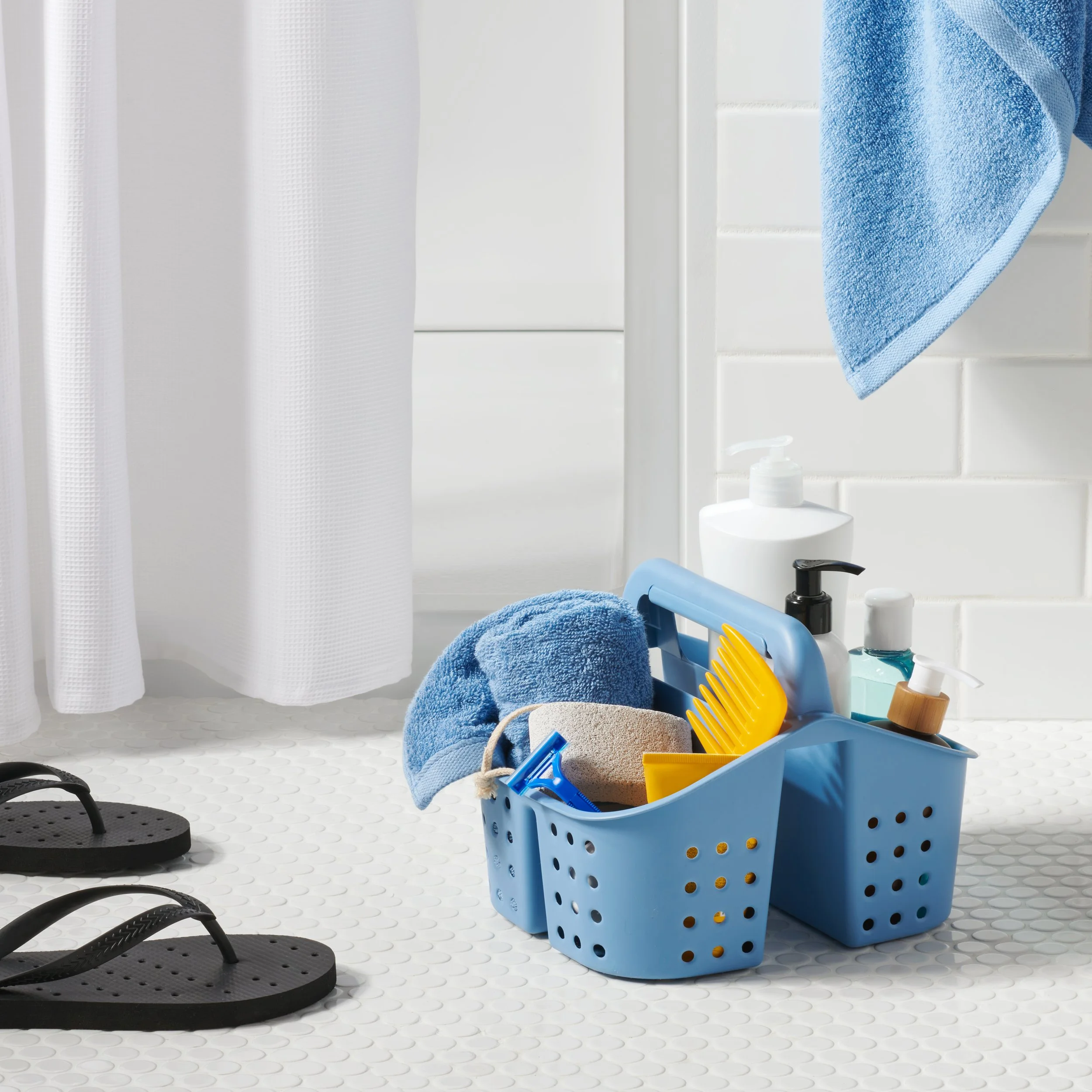 shower caddy in bathroom with towel flip flops shampoo comb