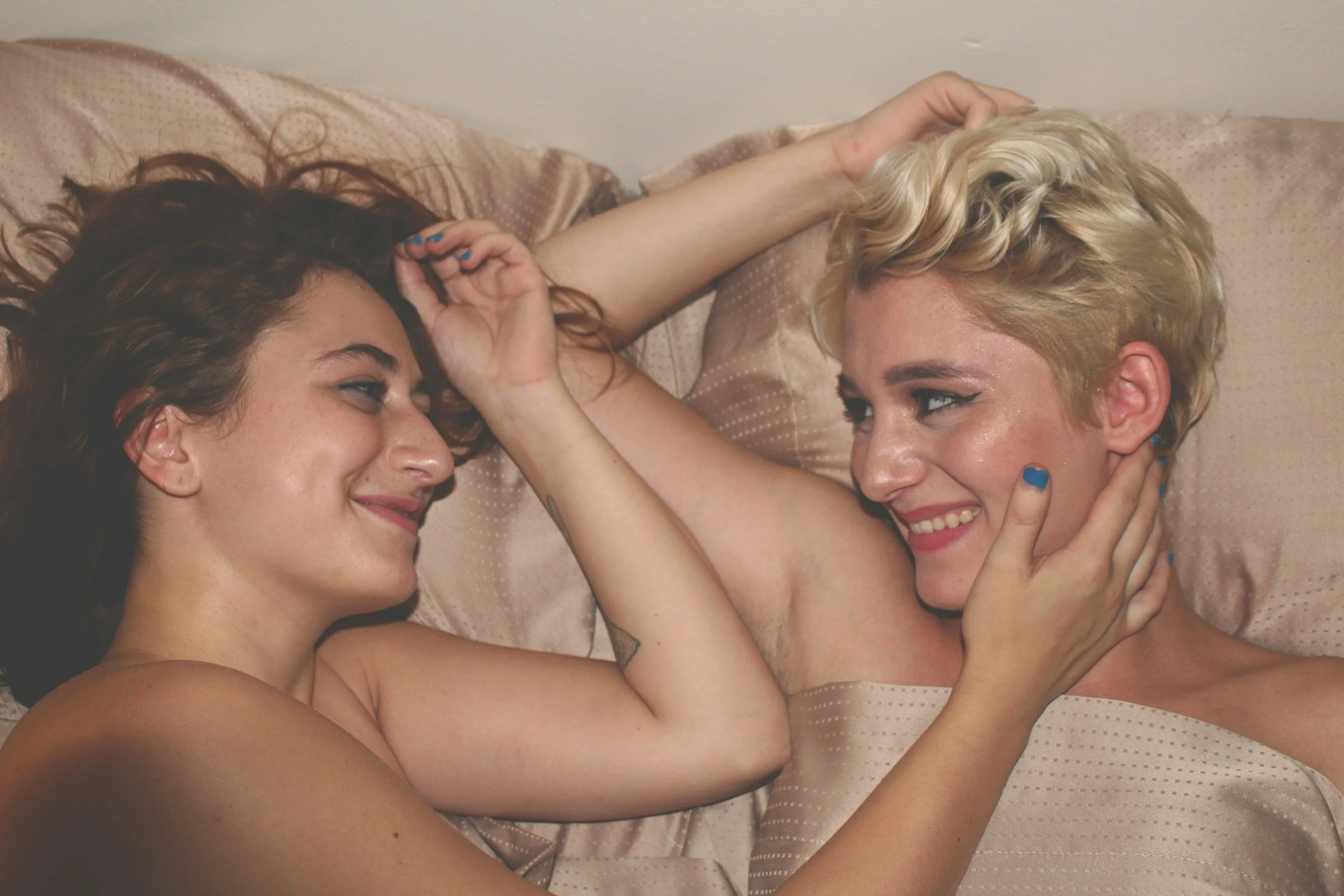 joyful lesbian couple in bed after sex