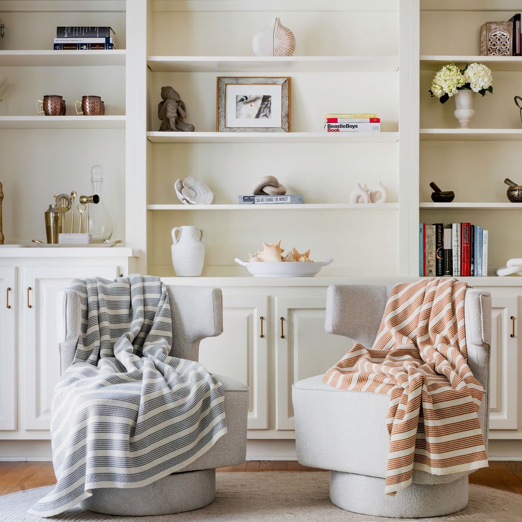 Coordinating striped throws photographed in a bright interior for home goods, textile and lifestyle brand marketing.