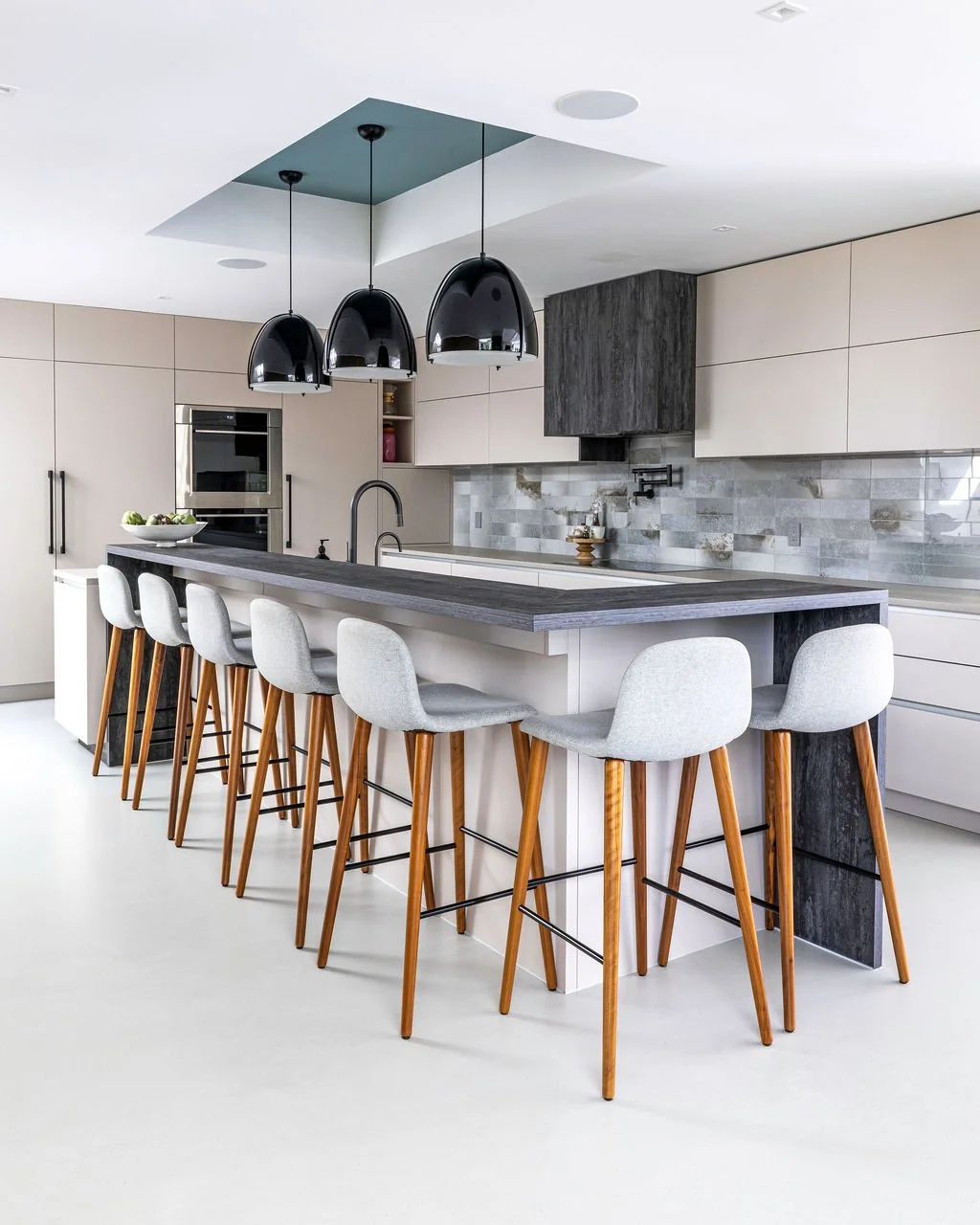 Architectural interior photography showing the relationship between kitchen design, lighting, materials and the surrounding living space.