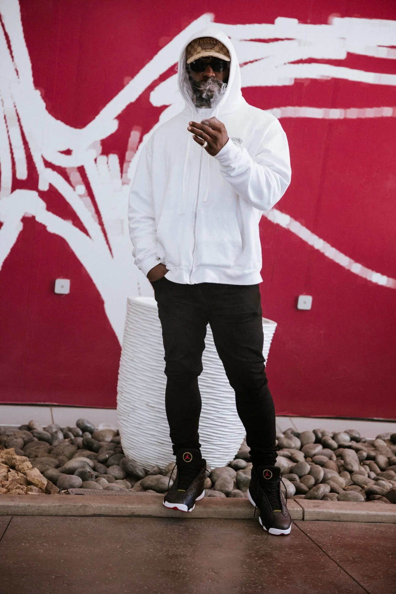 Street portrait against red mural with smoke — portrait photography — Universal Black Media Philadelphia