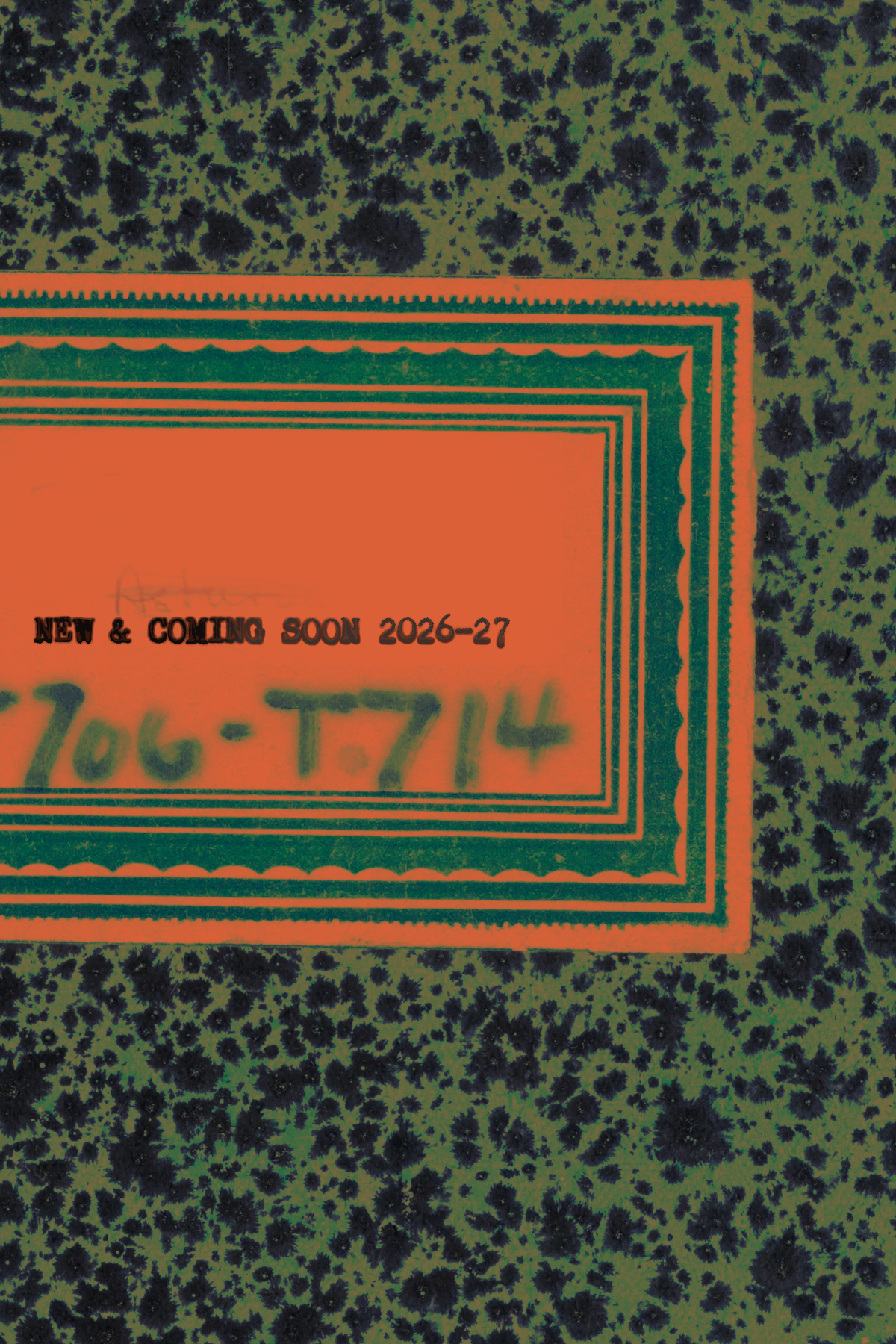 Close-up of a promotional sign with text indicating a future release for the years 2026-27, placed on a surface with a dark, speckled pattern.