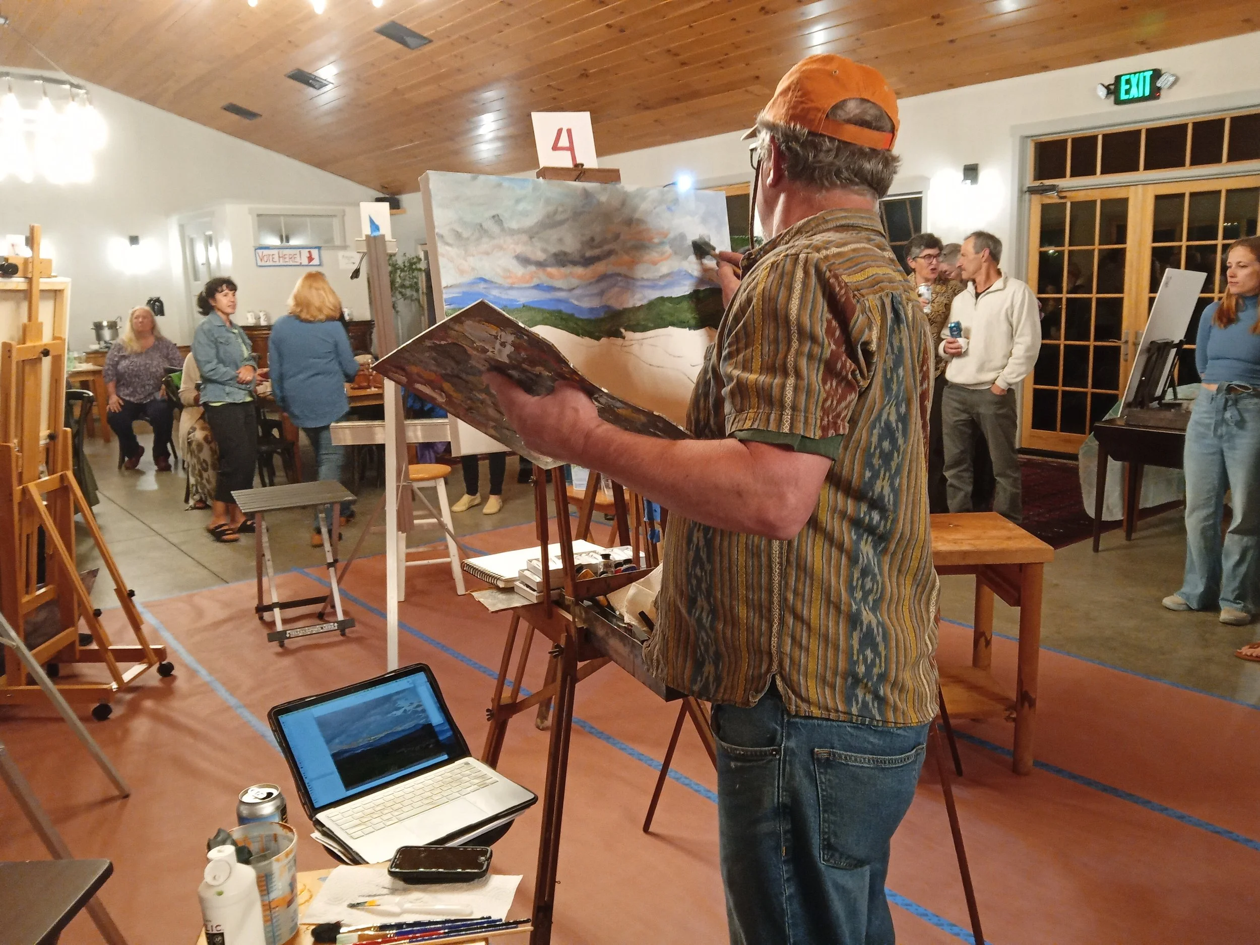 Main painting a landscape on canvas on easel.