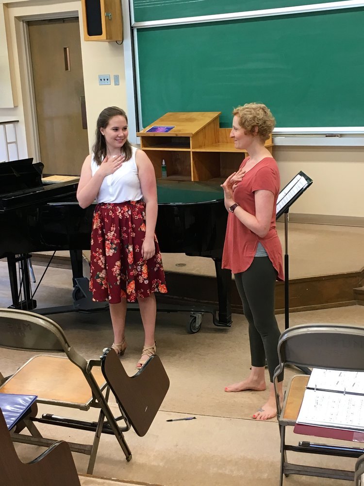 Two people with a hand on their own body, symbolizing how we work collaboratively to support your anxiety in therapy.