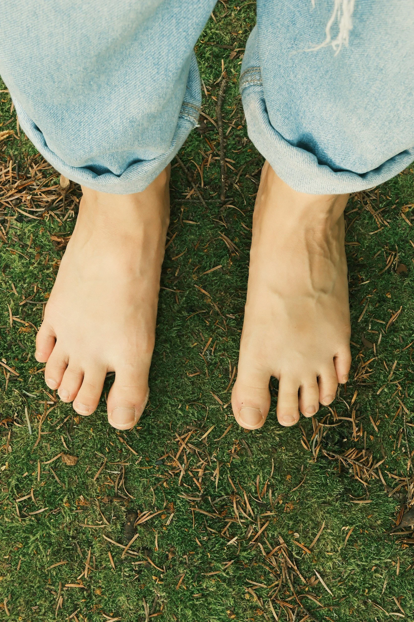 Soft gestures and steady feet connecting to the ground, conveying somatic grounding, emotional regulation, and embodied nervous system support.