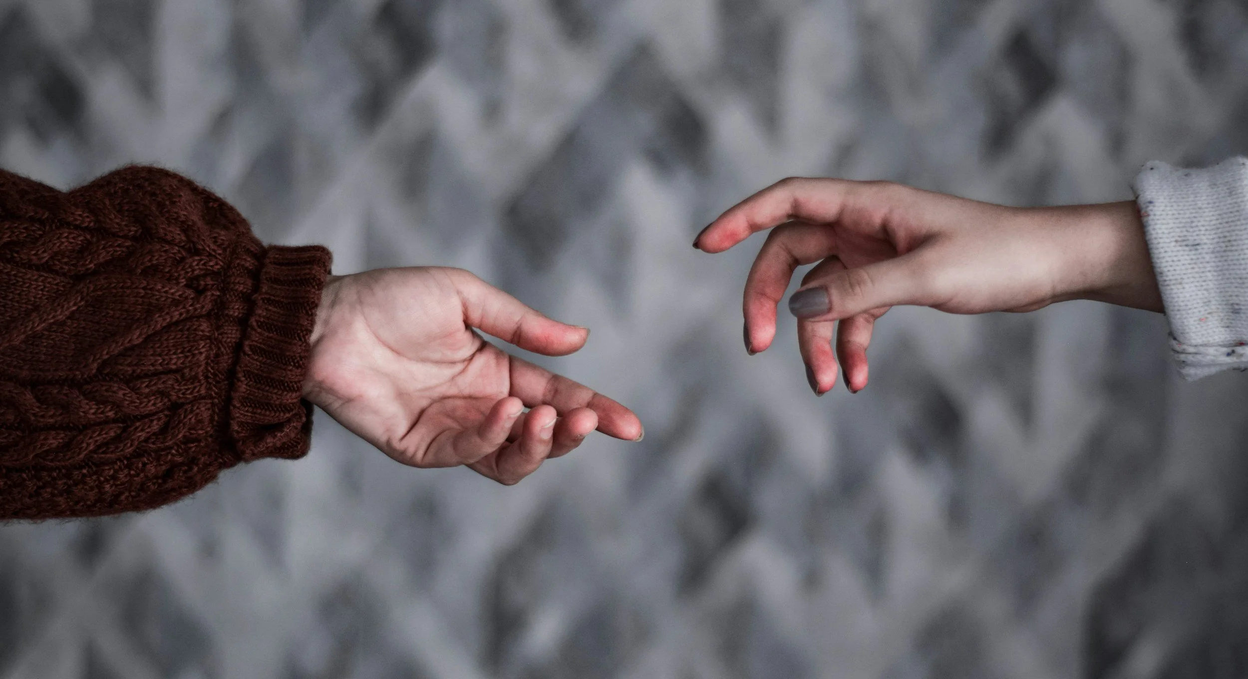 hands near each other without touching, showing the possibility of connection while respecting physical distance
