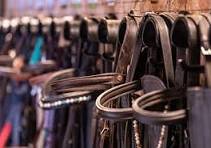 A row of belts hanging on a display rack in a store.
