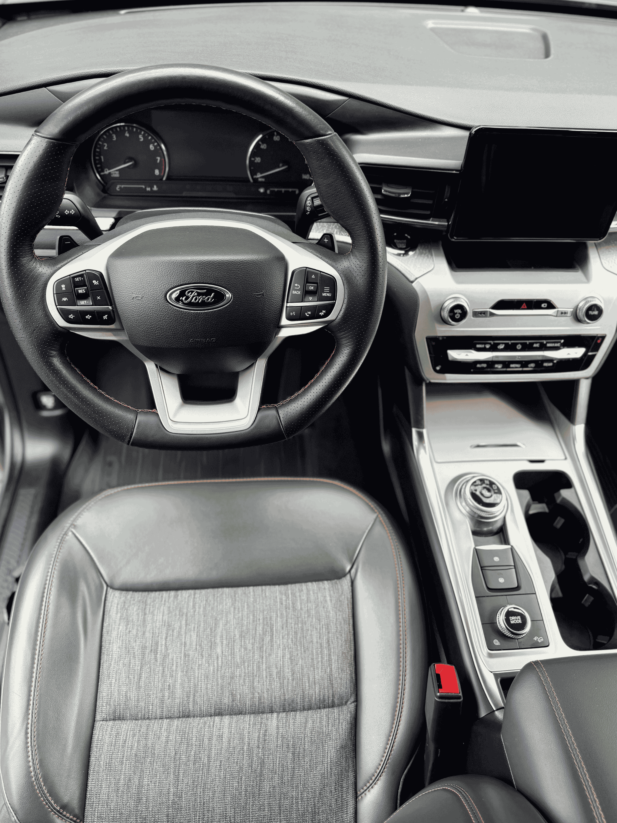 A professional interior detail of a modern Ford vehicle in NKY, showing a dust-free dashboard, large infotainment screen, and deep-cleaned cloth and leather upholstery.
