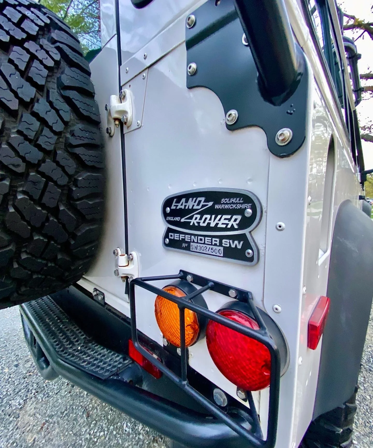 Side profile of a white Land Rover Defender parked in a residential NKY driveway, exhibiting a flawless exterior shine from a Full Signature Detail.