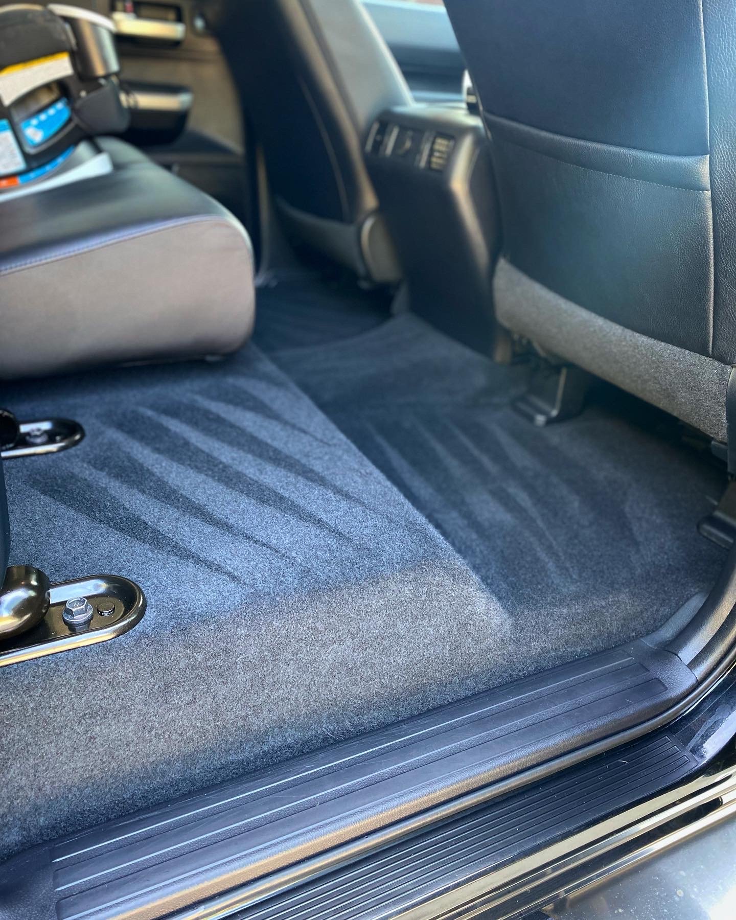 Close-up of a vehicle's carpeted interior showing pristine vacuum stripes and zero remaining debris after a professional pet hair removal detailing service in NKY.