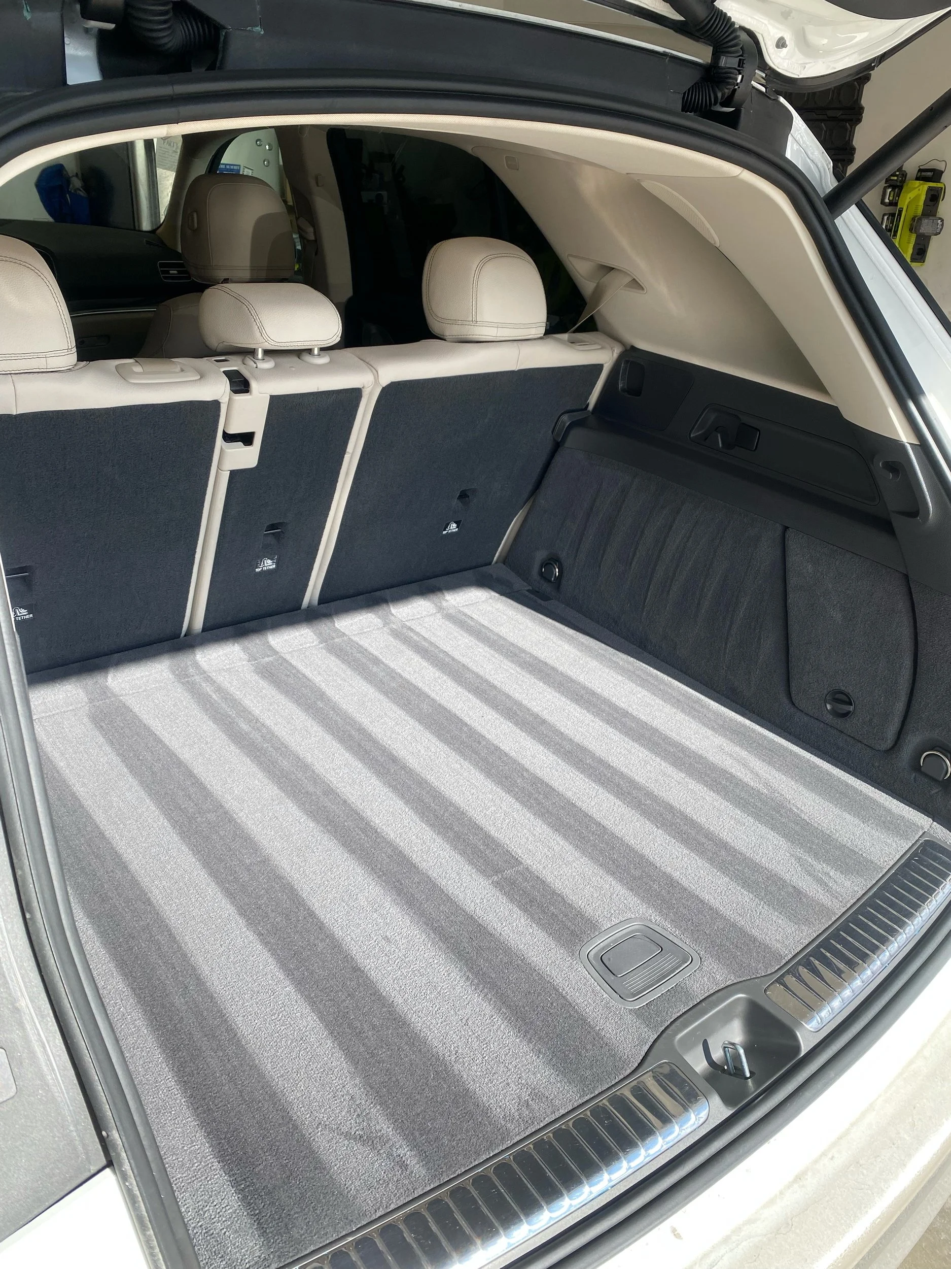 Professional interior detailing of a luxury SUV's trunk area in Cincinnati, featuring perfectly symmetrical vacuum lines on gray upholstery, demonstrating a deep-clean restoration.