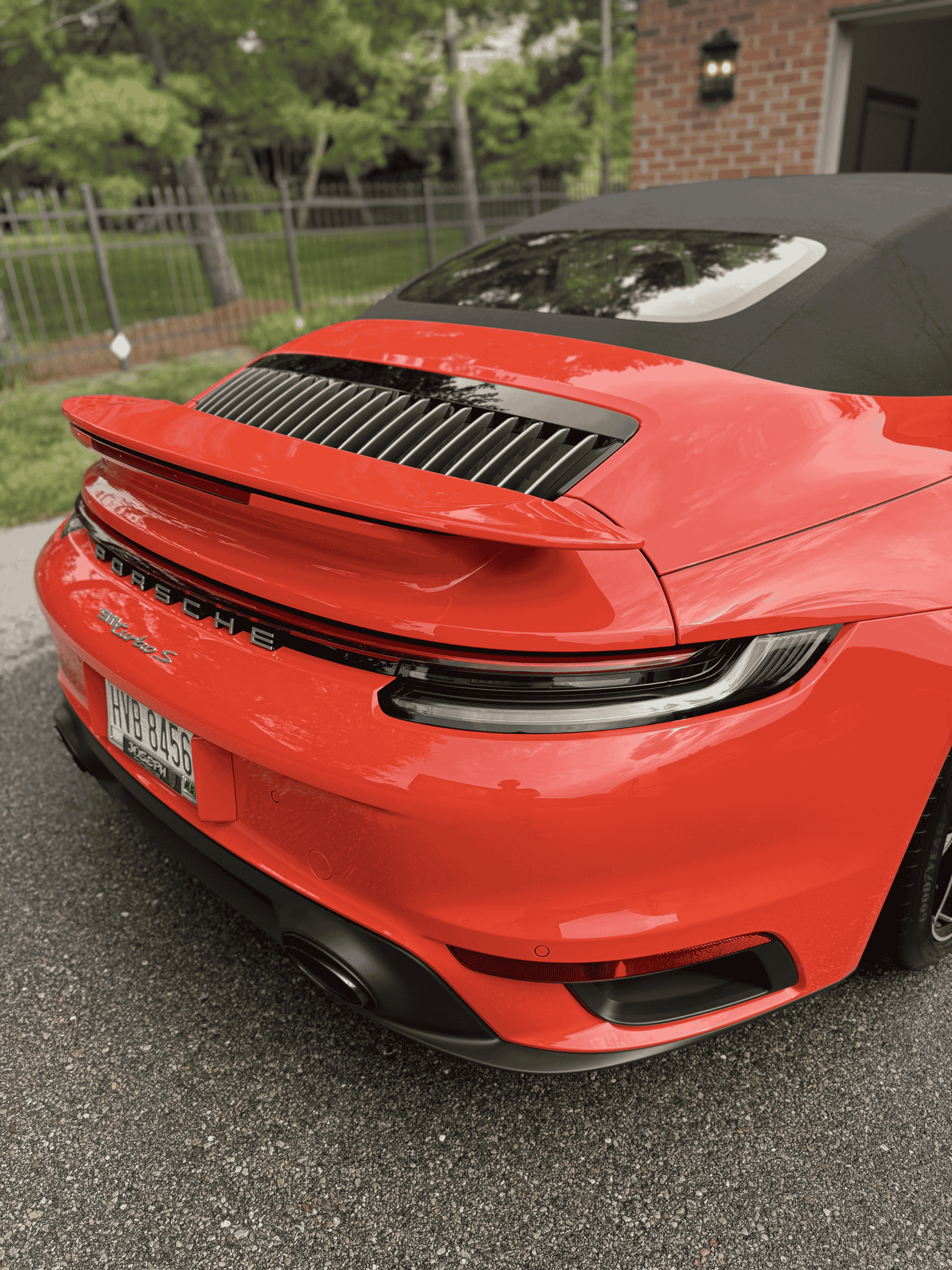 Rear profile of a vibrant red Porsche sports car with a flawless, reflective finish following a premium exterior detail in Northern Kentucky.