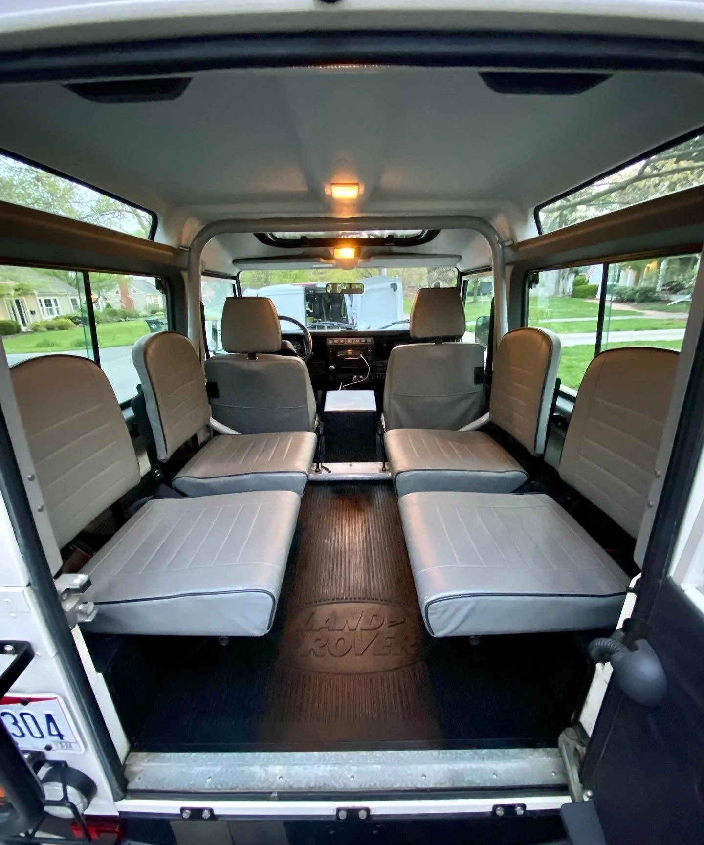 The interior of a multi-passenger shuttle bus in Northern Kentucky, showing rows of perfectly cleaned cloth seats and a spotlessly vacuumed center aisle.