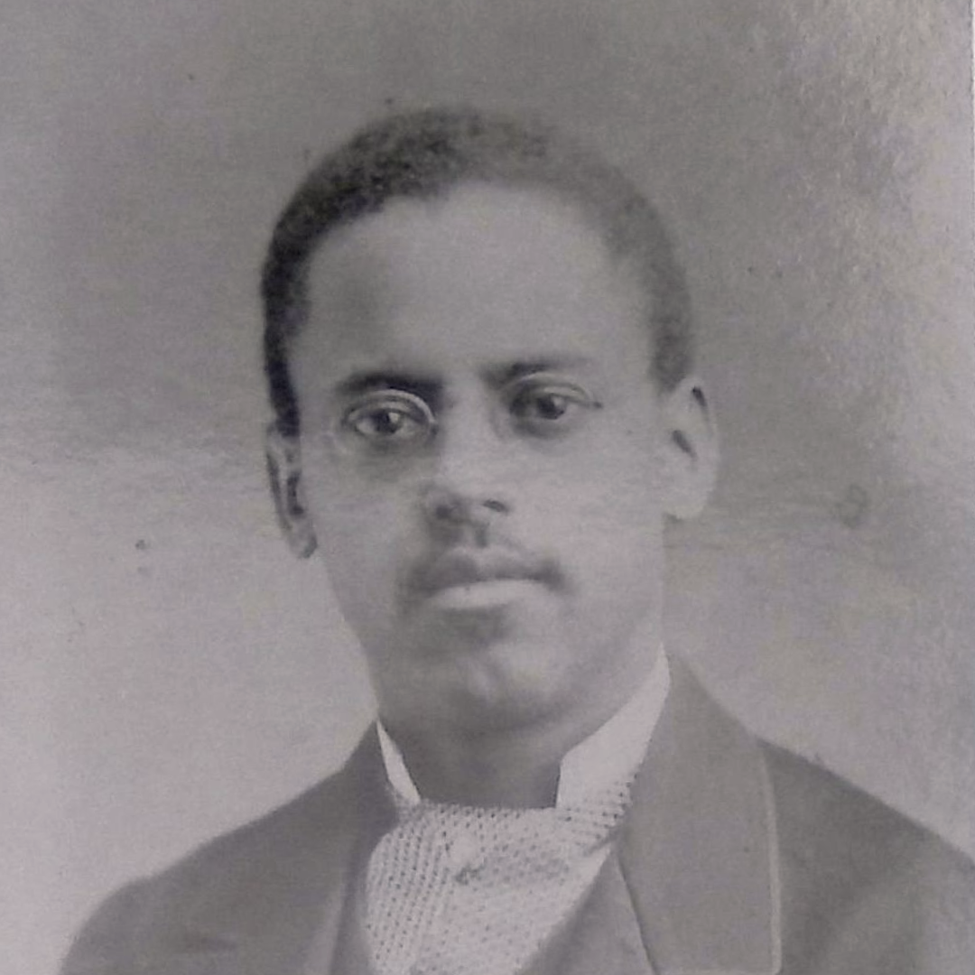 A black-and-white portrait of Lewis Latiemr wearing a suit and bow tie.