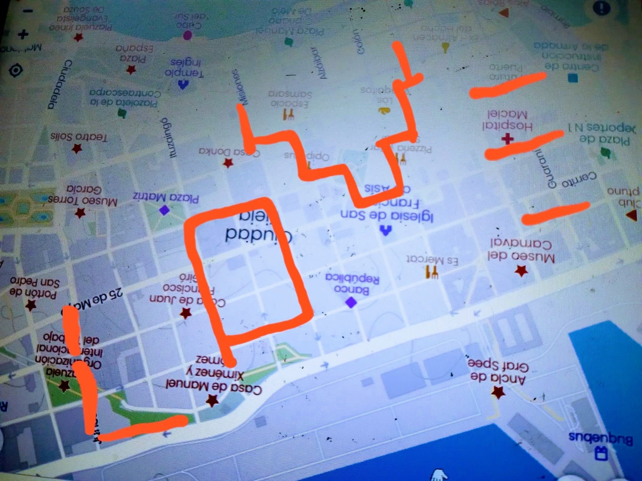 Mapa turístico de una ciudad, con rutas resaltadas en naranja y varias atracciones marcadas con estrellas y símbolos, incluyendo museos y parques.