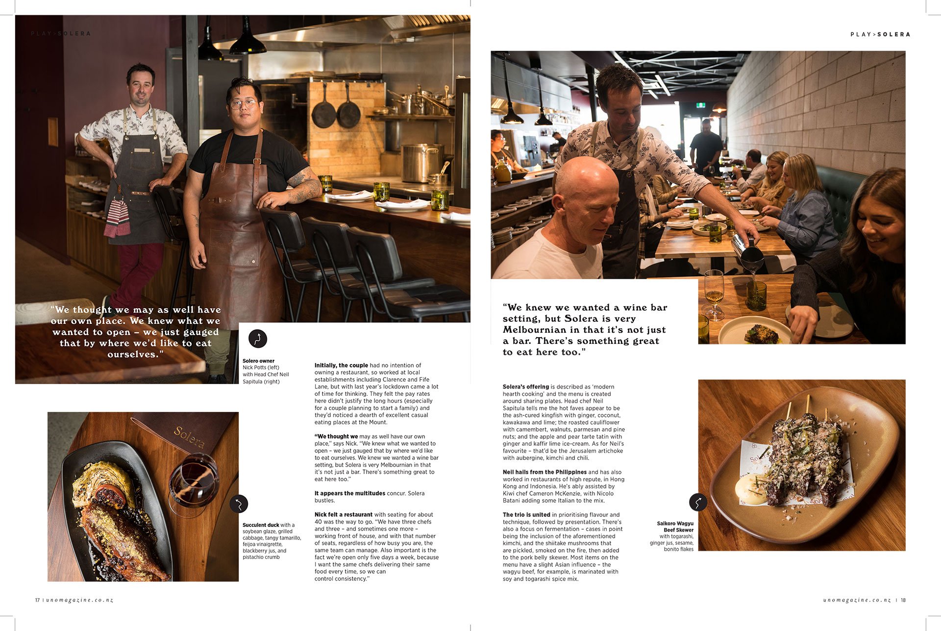 The image shows two pages of a magazine article about a restaurant. The left page features two male chefs standing in a kitchen, smiling and looking at the camera. The right page depicts a waiter pouring wine for a group of customers dining at a long wooden table in a modern restaurant setting.