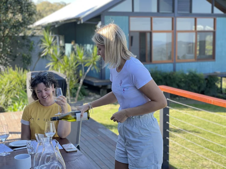 Kat pouring wine for guests at an outdoor private tasting