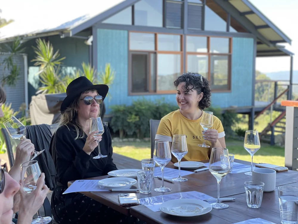 Guests sharing an outdoor private wine tasting around the table