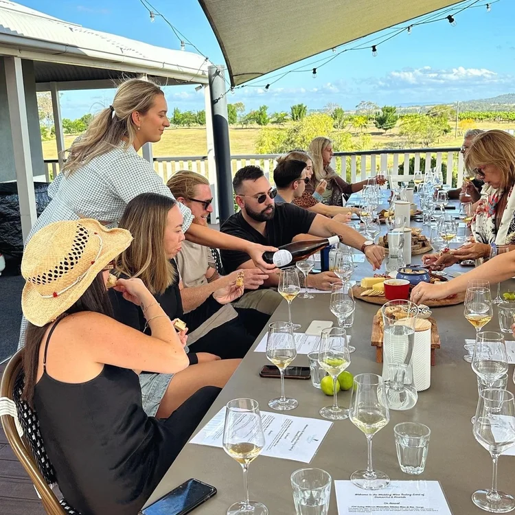 Kat pouring wine for guests at a wedding celebration at Willow Tree Estate