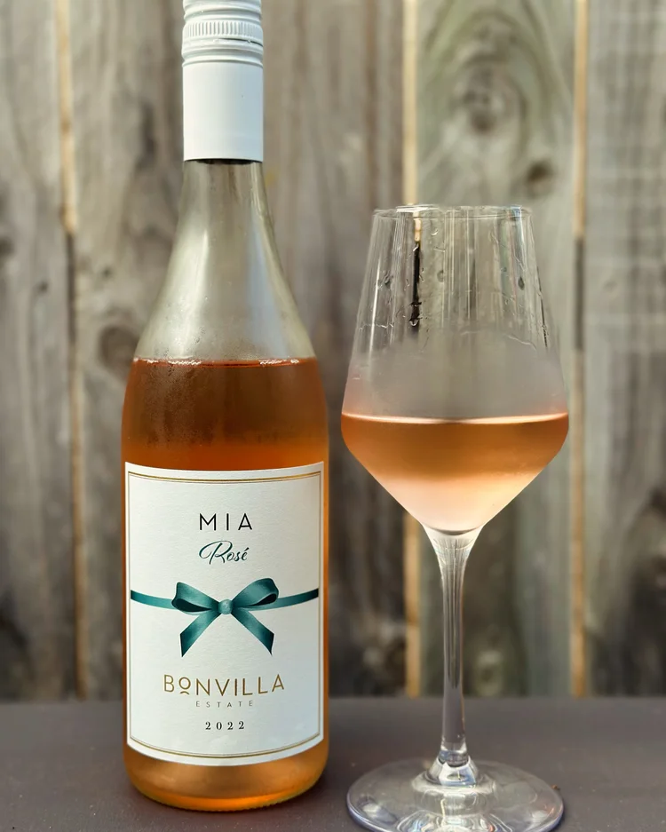 A bottle of rosé beside a filled wine glass