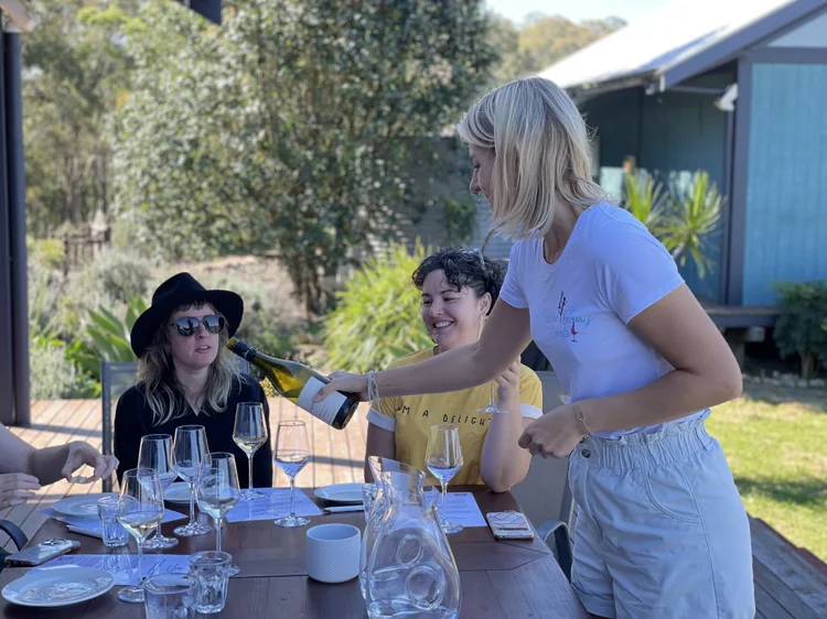 Kat pouring wine for guests at an outdoor private tasting