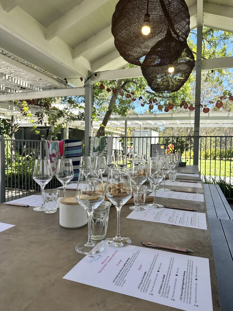 Wine glasses and tasting notes set up on a verandah at Whitevale Estate