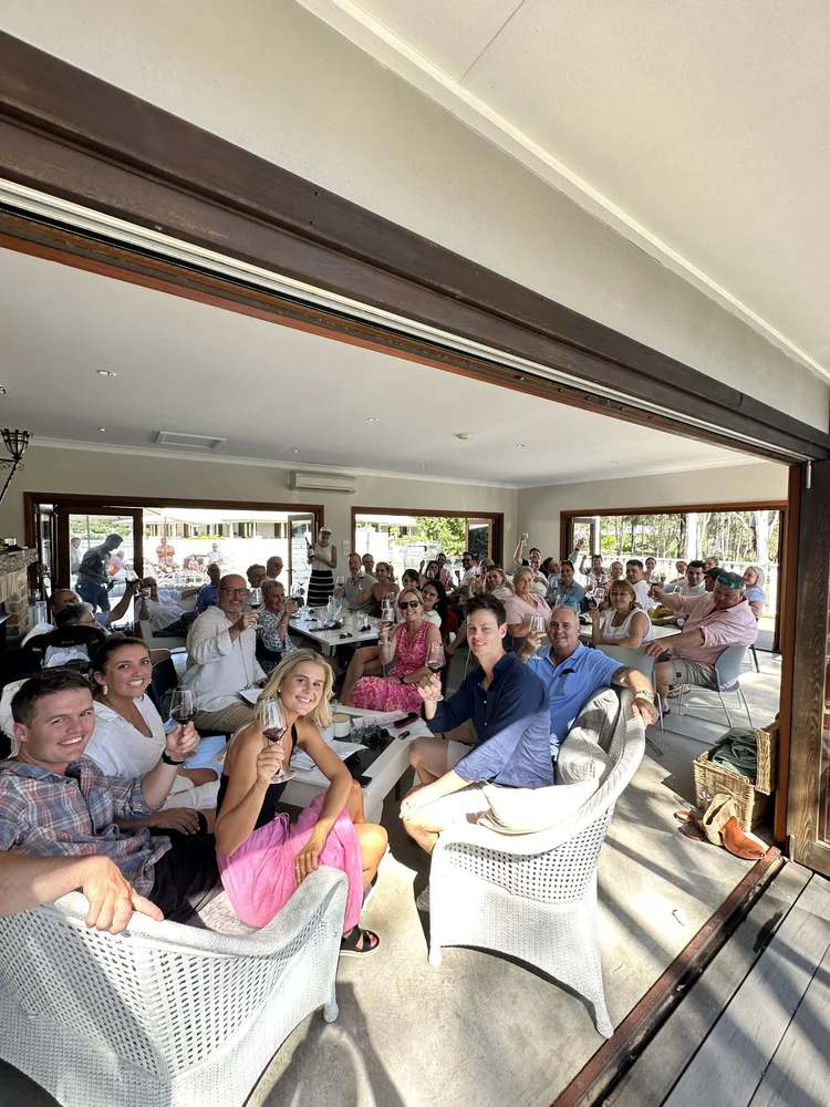 Wedding guests raising their glasses during a group wine tasting