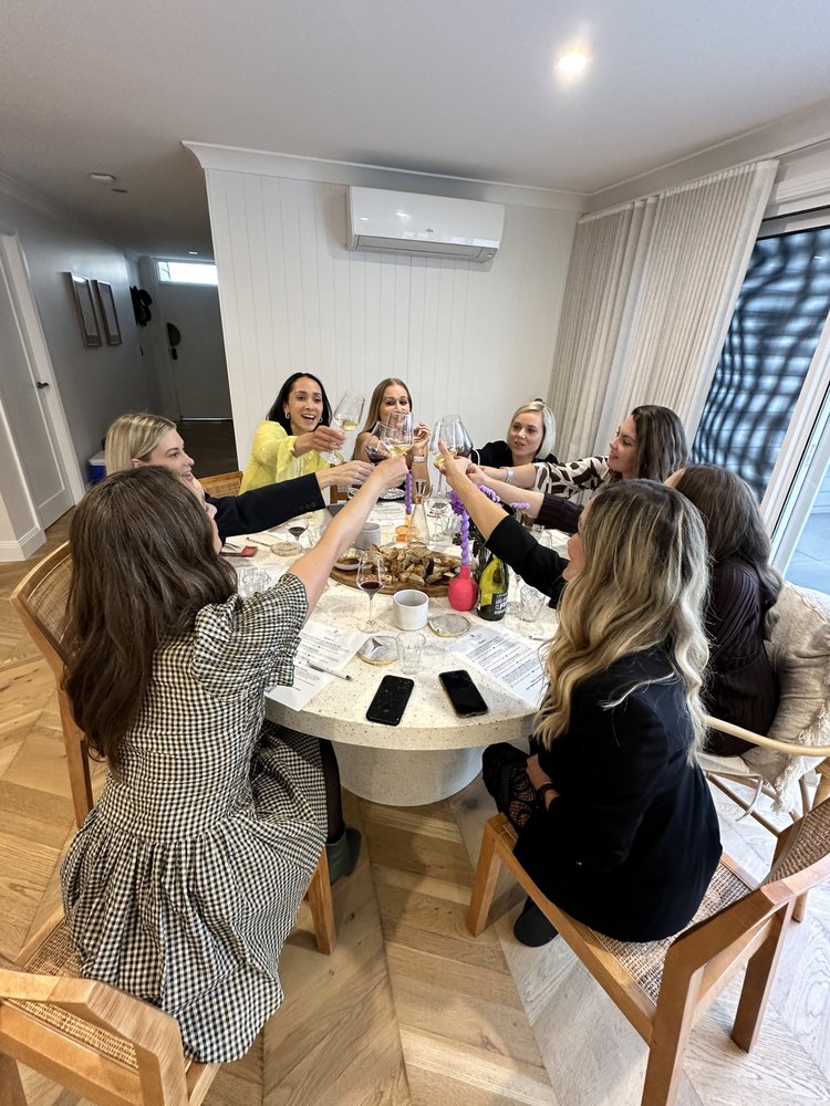 Guests raising wine glasses together around a tasting table