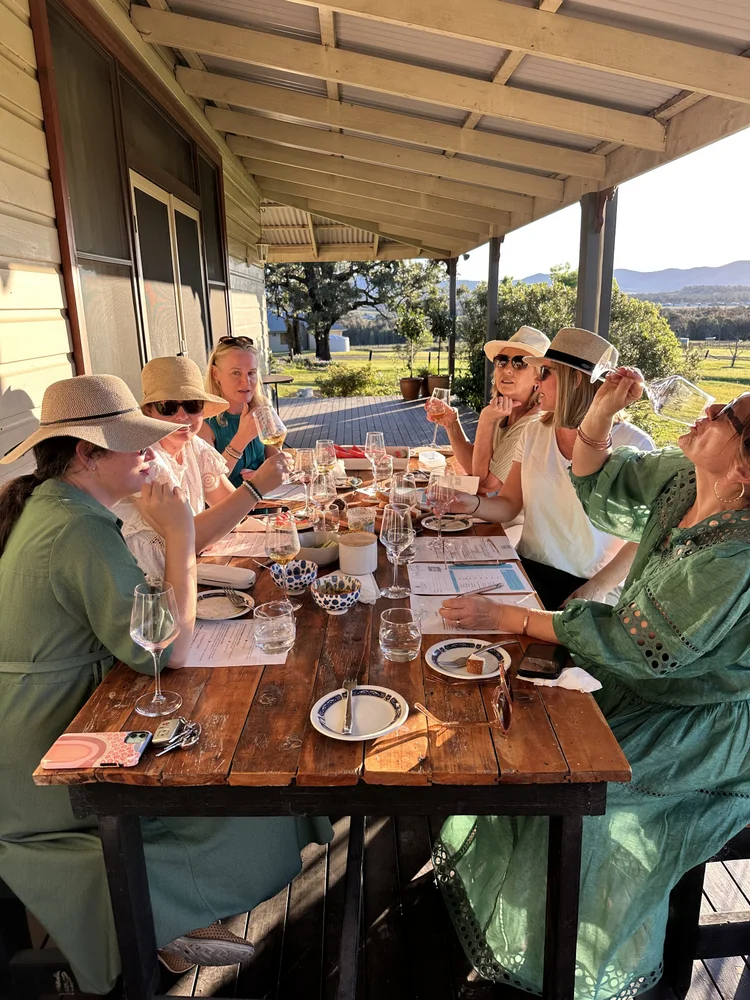 Guests enjoying a wine tasting together on a vineyard verandah