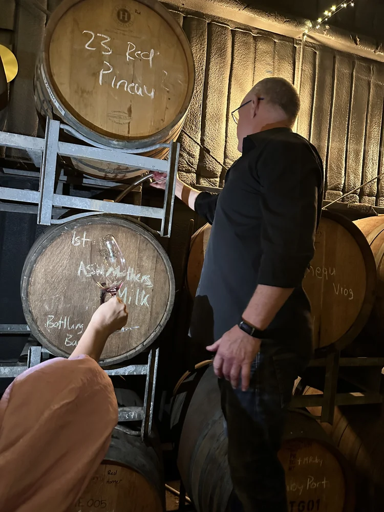 A guest sampling wine from a barrel at Horner Winery