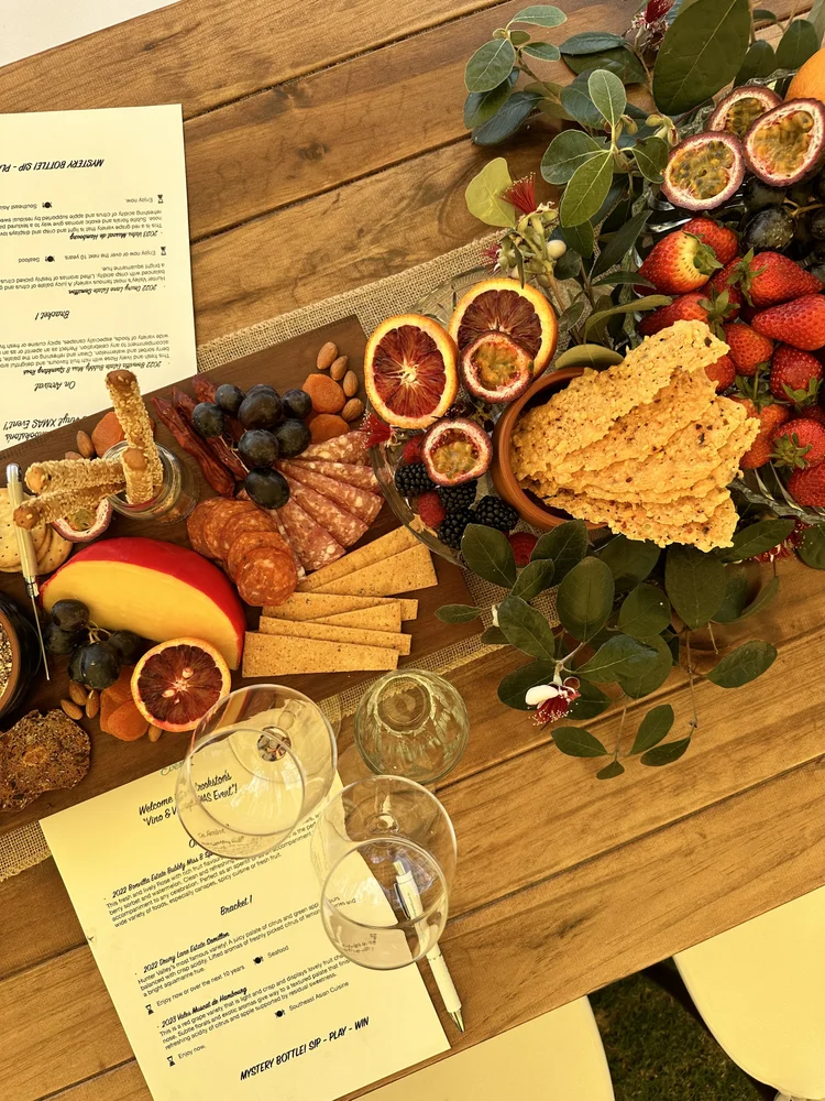 Wine glasses, tasting notes and a cheese platter arranged on a table