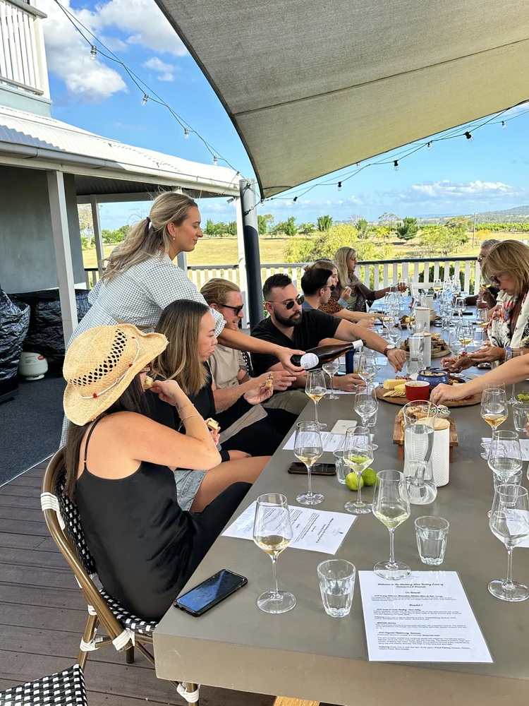 Kat pouring wine for guests at an outdoor private tasting