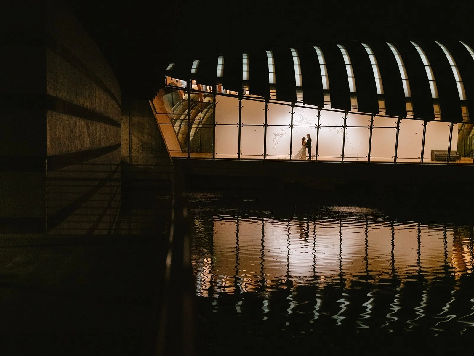 romantic wedding day image of a bride and groom inside the crystal bridges museum in bentonville arkansas at night
