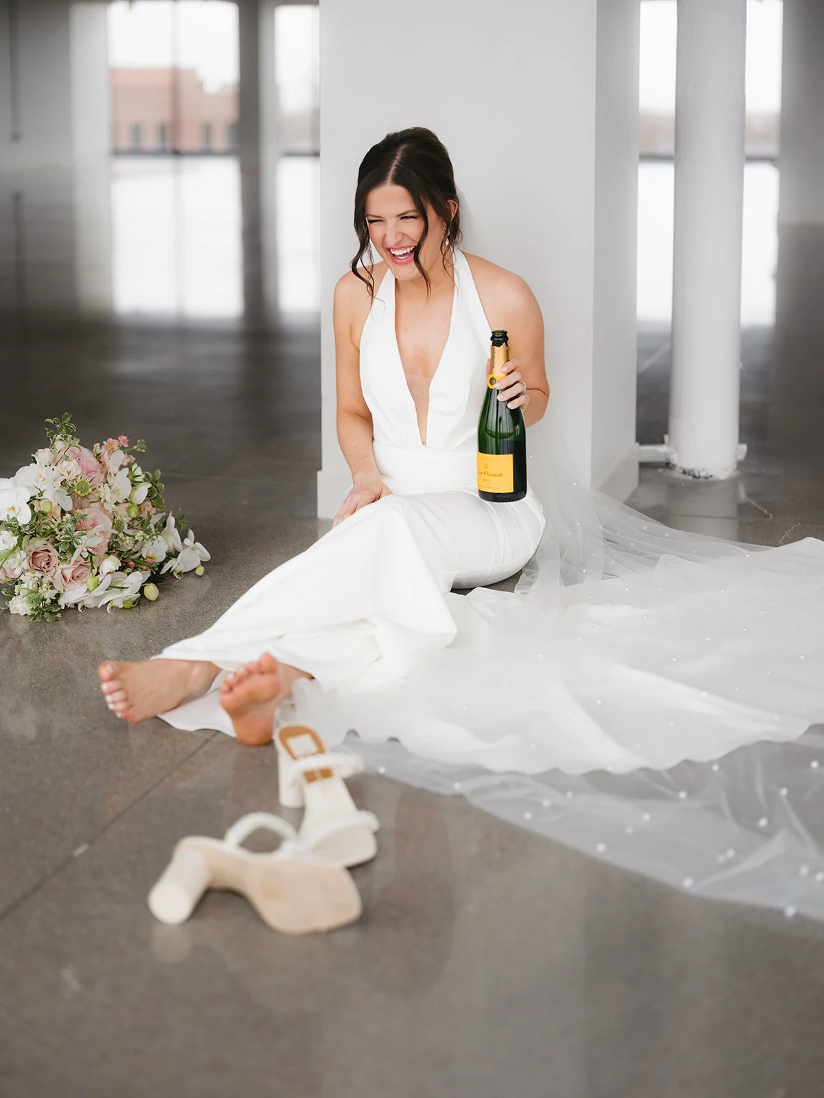 Bride sips Champagne during her photoshoot at the Ledger in Bentonville