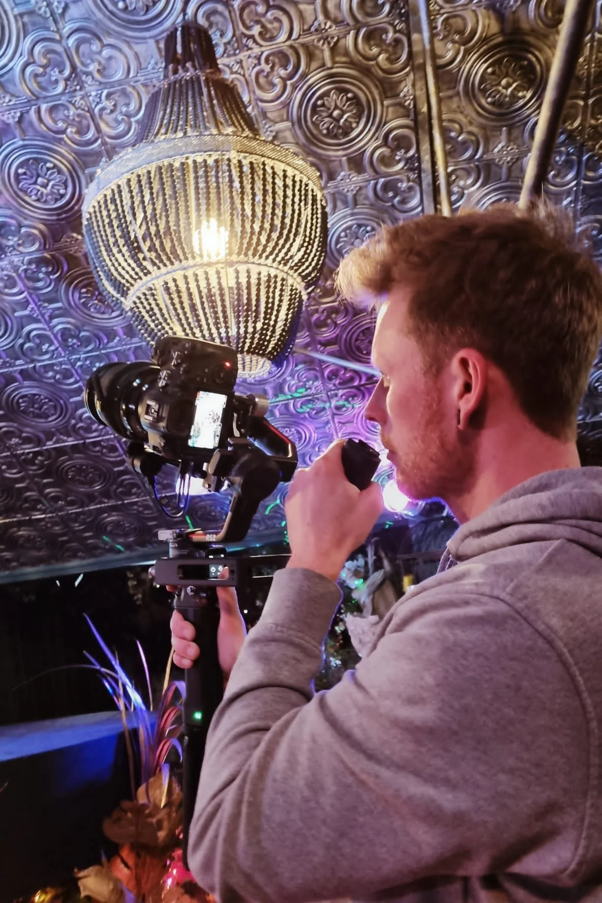 An image of Thomas Stanley, a videographer holding a Ronin RS3 Pro with a Sony A7IV on it, shooting an event at The Garden Society.