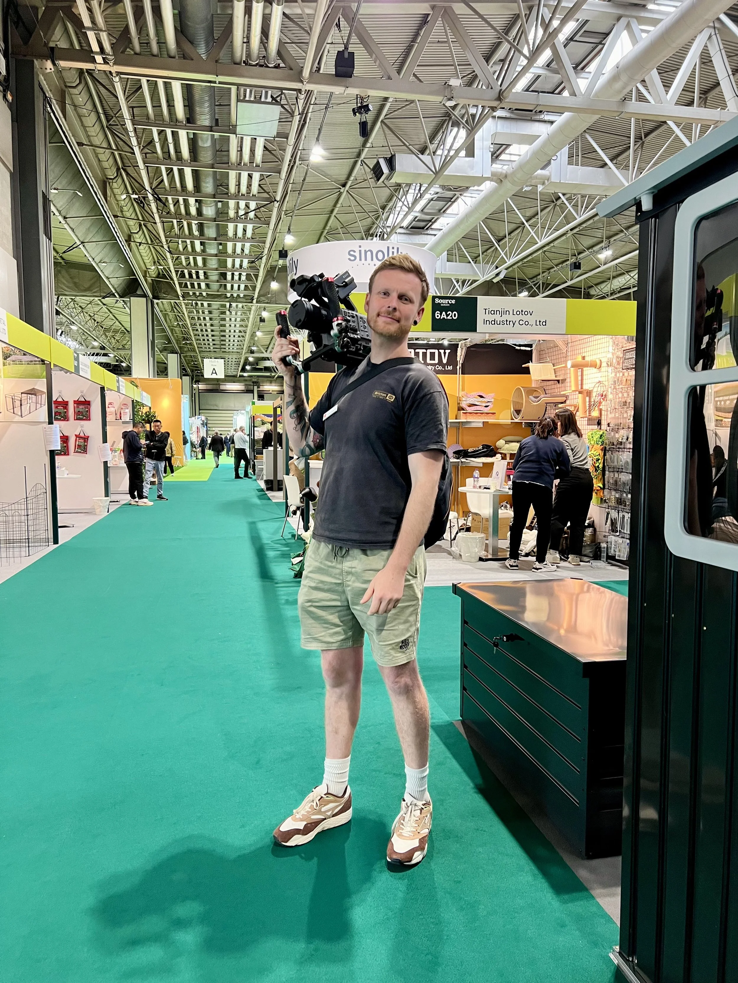 Image of Thomas Stanley at Source Garden in the Birmingham NEC holding a Sony FX6 Camera over his shoulder.