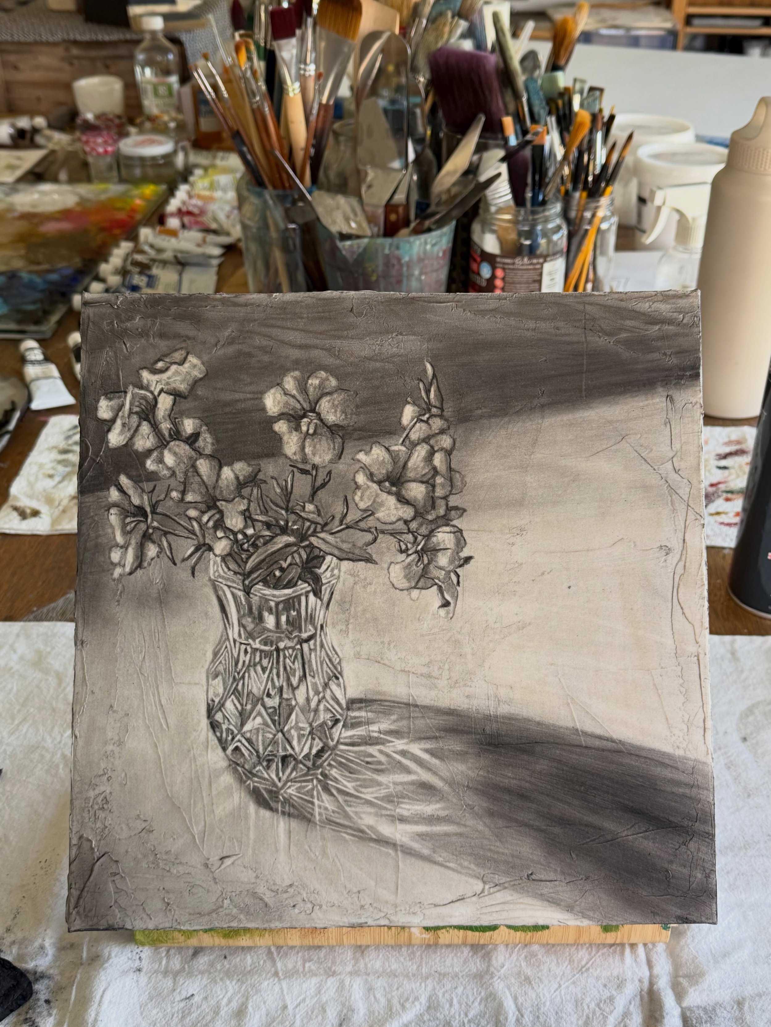 On the easel today. The third in this little series of vintage crystal vases and small blooms. Charcoal done, just a touch of colour to the flowers and it should be finished. You wouldn&rsquo;t think it but the vase was relatively easy compared to th