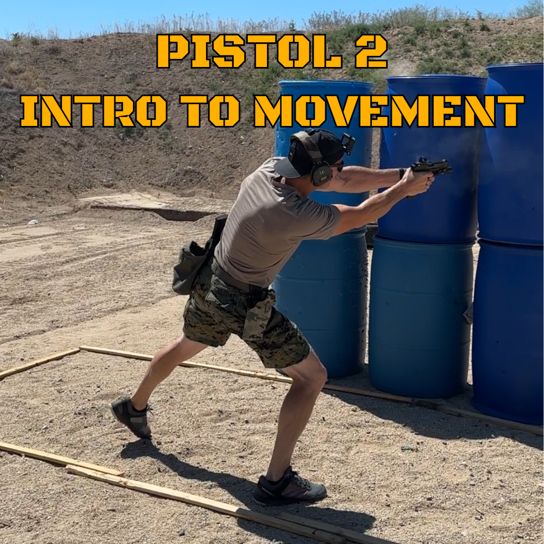 A person wearing protective ear muffs, a baseball cap, a grey t-shirt, and camouflage shorts practicing shooting with a pistol at an outdoor shooting range, aiming at blue barrels.